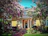 A welcoming entrance to a charming guesthouse surrounded by blooming flowers.