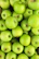 Vibrant green apples neatly arranged in premium packaging with a gold-accented label.