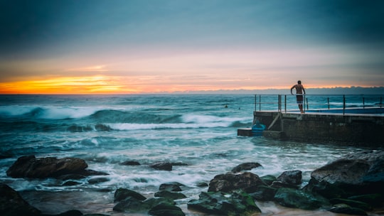 man standing on brown concrete docking station in Curl Curl Australia