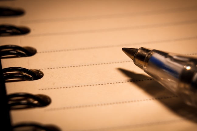 A close-up of a sleek ballpoint pen on a notebook.