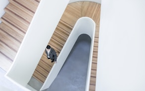 person stepping down on brown wooden stairs aerial photography