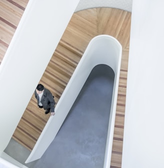 person stepping down on brown wooden stairs aerial photography