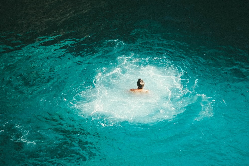 photo of person swimming on body of water
