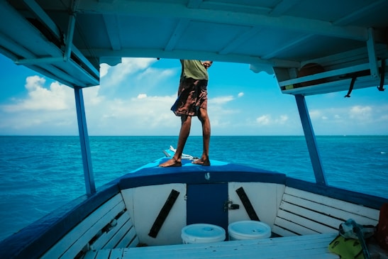 A confident seafarer standing on deck with a vast ocean horizon behind, symbolizing opportunity and adventure.