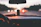 Close-up of a vanilla-scented custom air freshener hanging from a rearview mirror with a blurred dashboard background.
