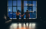 man and woman holding hands in front of glass window
