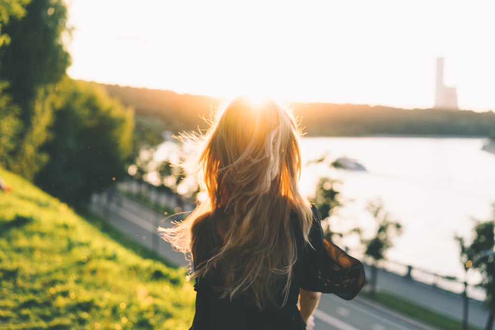 mulher sentada enquanto olha para o pôr do sol