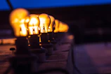 A row of LED bulbs lit up against a dark background highlighting their warm yellow glow.