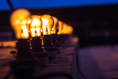A row of LED bulbs lit up against a dark background highlighting their warm yellow glow.