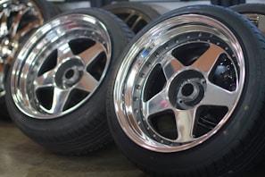 Set of shiny alloy wheels stacked neatly in a bright garage