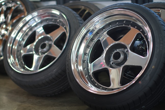 A collection of various aluminium wheels and rims stacked together.
