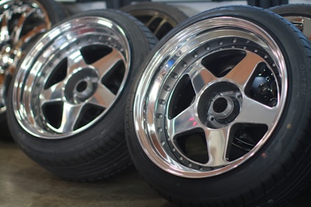 A collection of various aluminium wheels and rims stacked together, showcasing their different conditions and types.