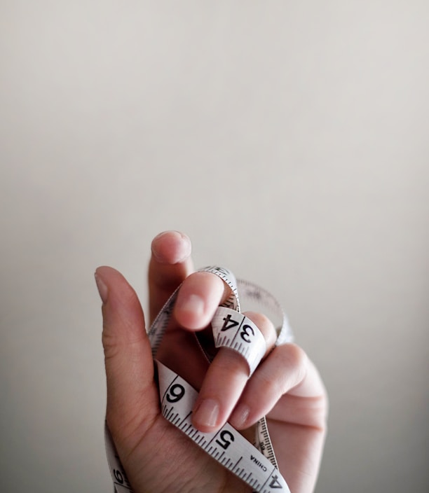 person's left hand wrapped by tape measure