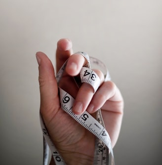 person's left hand wrapped by tape measure