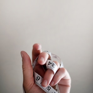 person's left hand wrapped by tape measure