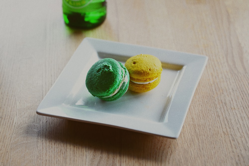 zwei Macarons aus quadratischem weißem Teller