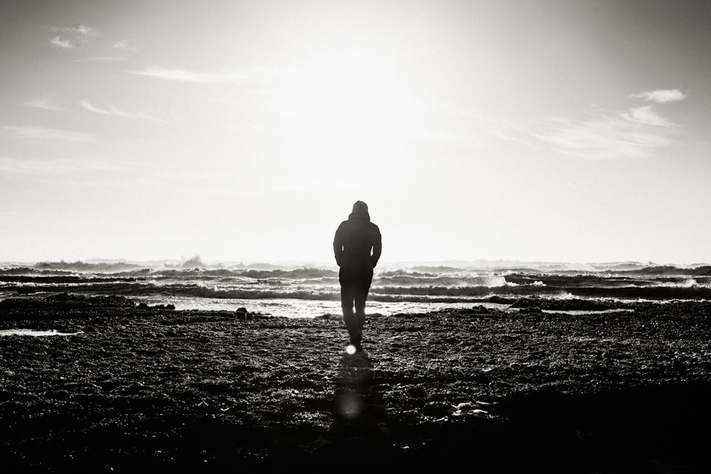 man standing near ocean grayscale photography