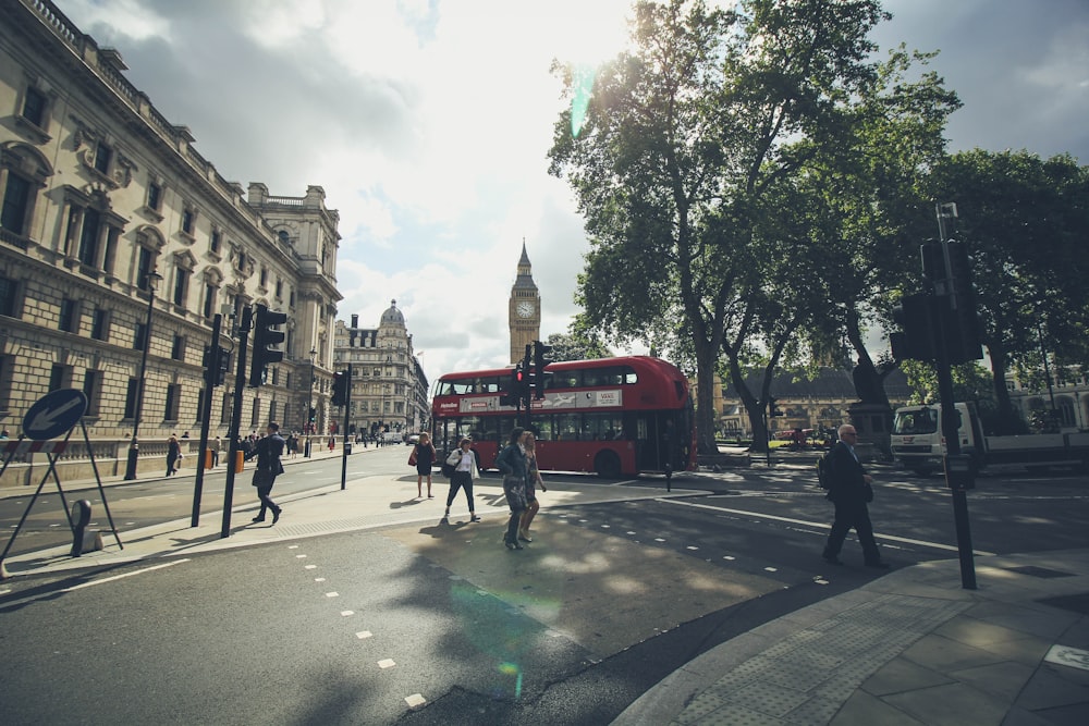 group of people walking on London road beside double deaker bus