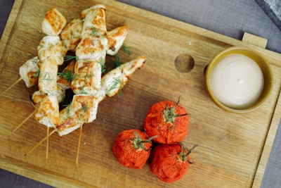 Freshly grilled chicken skewers resting on a bed of herbs and spices.