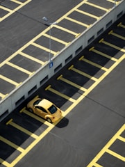 yellow coupe on parking lot at daytime