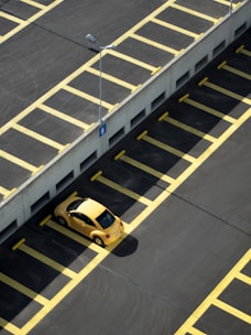 yellow coupe on parking lot at daytime