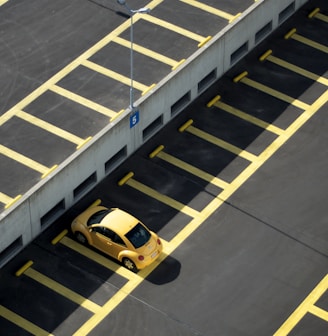 yellow coupe on parking lot at daytime