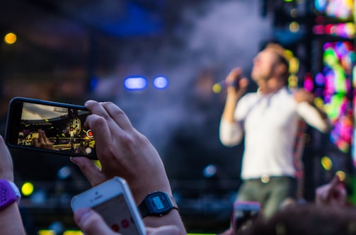 Close-up of a photographer capturing a live music performance.