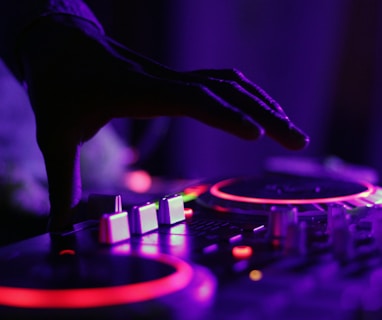selective focus silhouette photography of man playing red-lighted DJ terminal