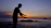 A serene photo of a mature woman practicing tai chi outdoors at sunrise.