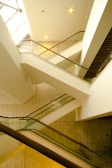 Architectural detail of a custom staircase with glass balustrades and wooden steps.