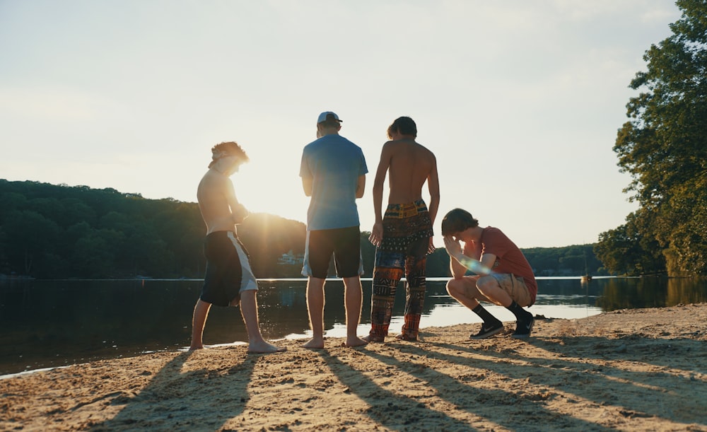 a group of people standing on top of a sandy beach