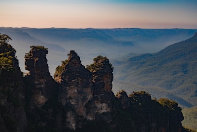 Scenic view of the Three Sisters mountains with a clear blue sky and lush forest.