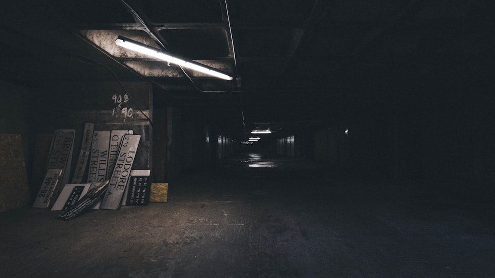 assorted signages leaning on wall and dark hallway