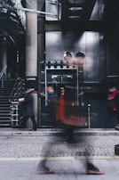 A professional doorman welcoming guests at a stylish building entrance.