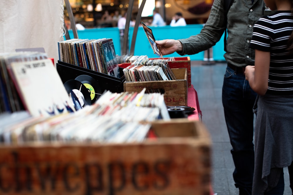 Hommes debout devant une vente de disques vinyles