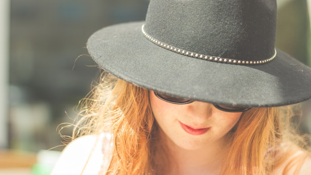 woman looking down wearing black bowler hat