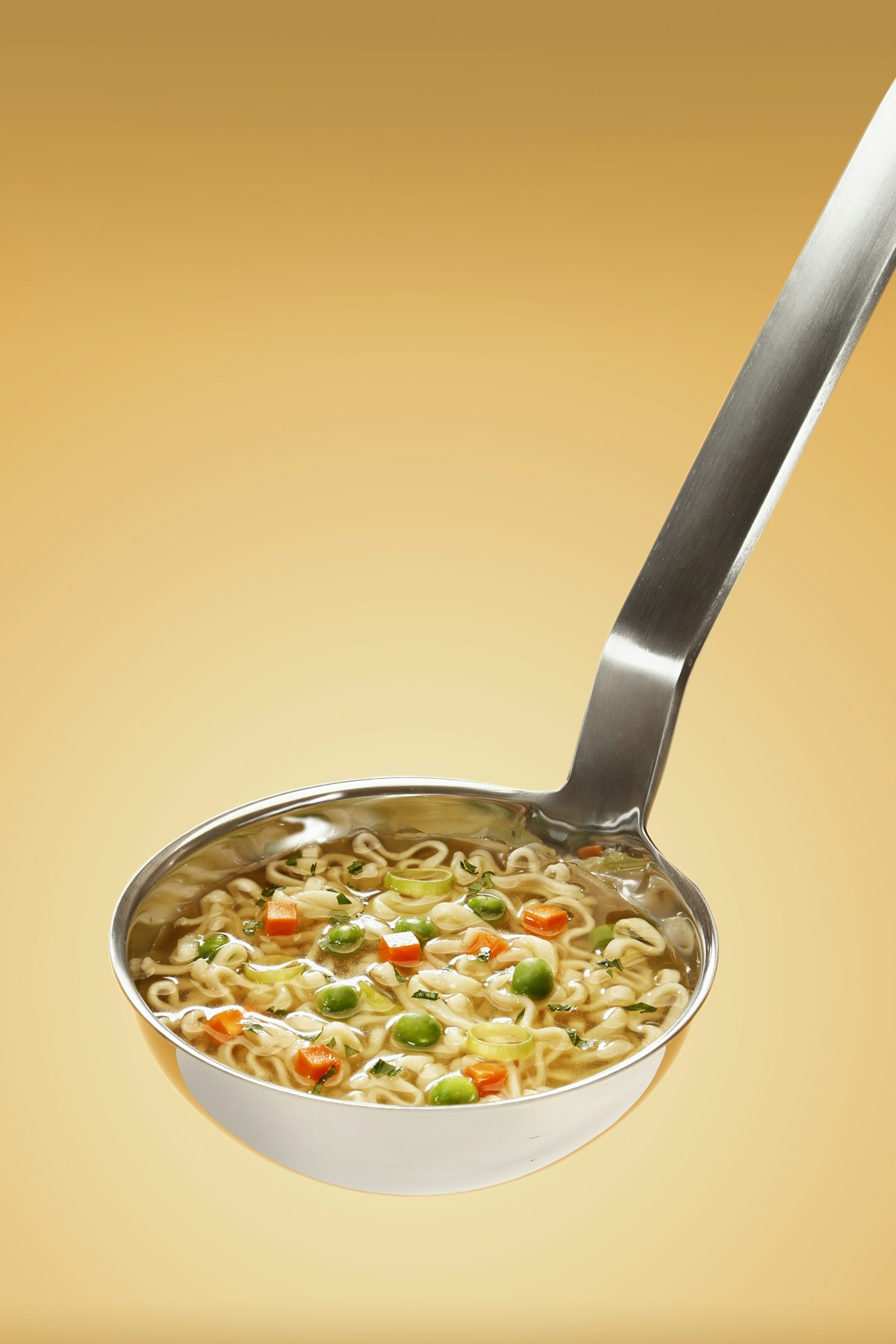 Steaming pot of chicken noodle soup with shredded chicken, carrots, celery and egg noodles