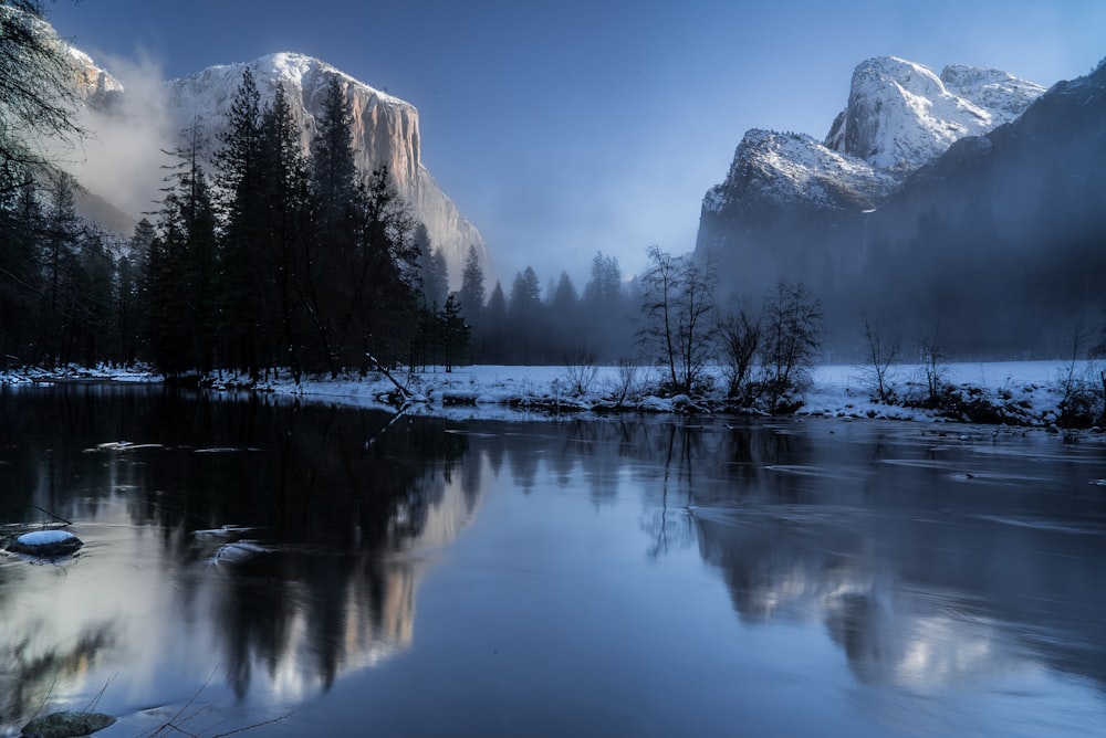 reflexo de montanhas e árvores no corpo de durante a neve