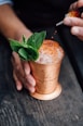 brass-colored cup filled with crushed ice with mint