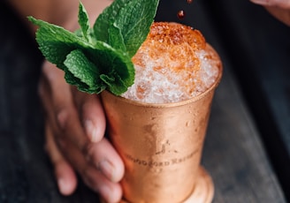 brass-colored cup filled with crushed ice with mint