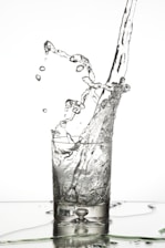 Water droplets falling into a glass from the Kent Grand+ purifier spout.