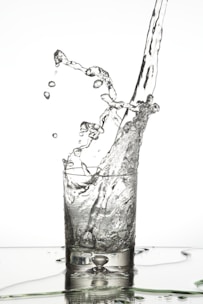 Water droplets falling into a glass from the Kent Grand+ purifier spout.