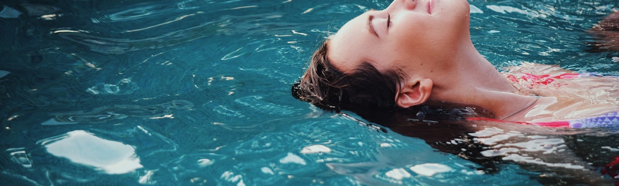 woman floating on body of water