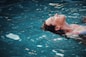 woman floating on body of water