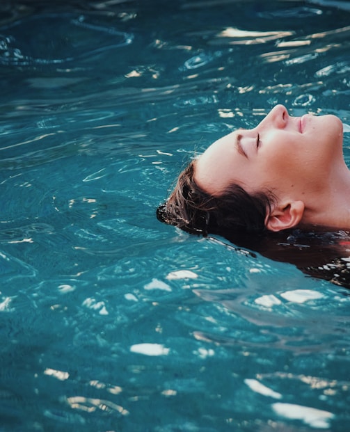 woman floating on body of water