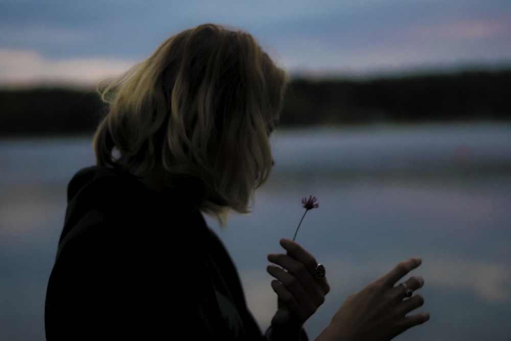 mujer sosteniendo flor