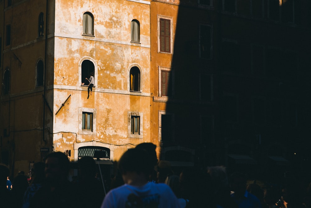 person sitting on building window