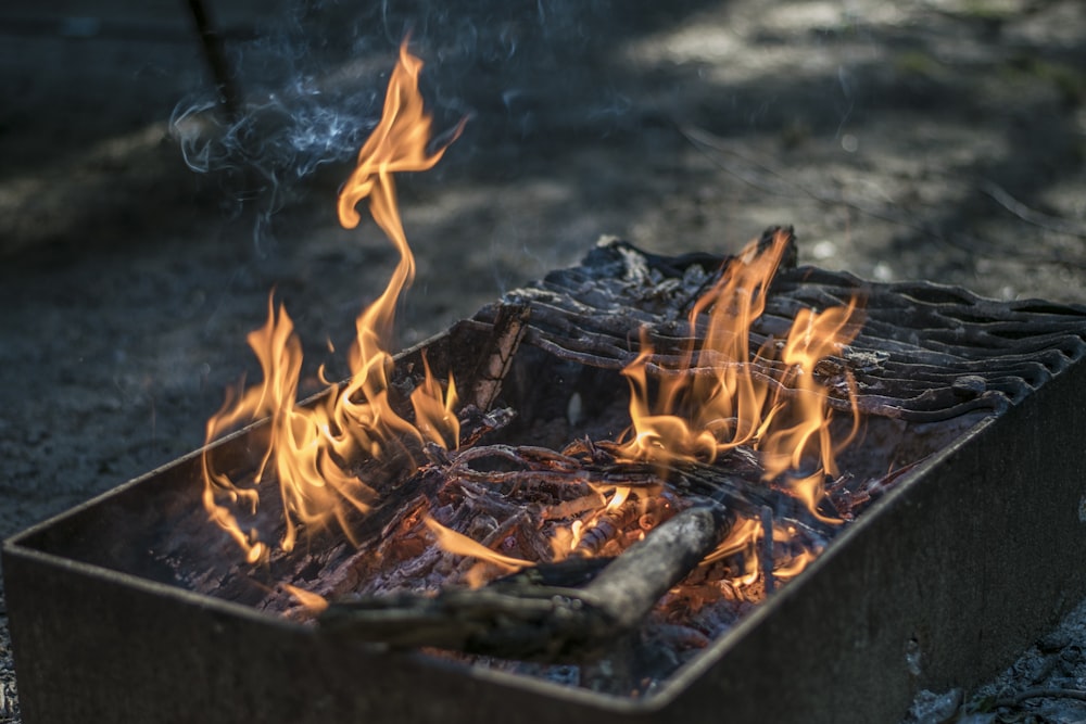rectangular black fire pit with fire at daytime