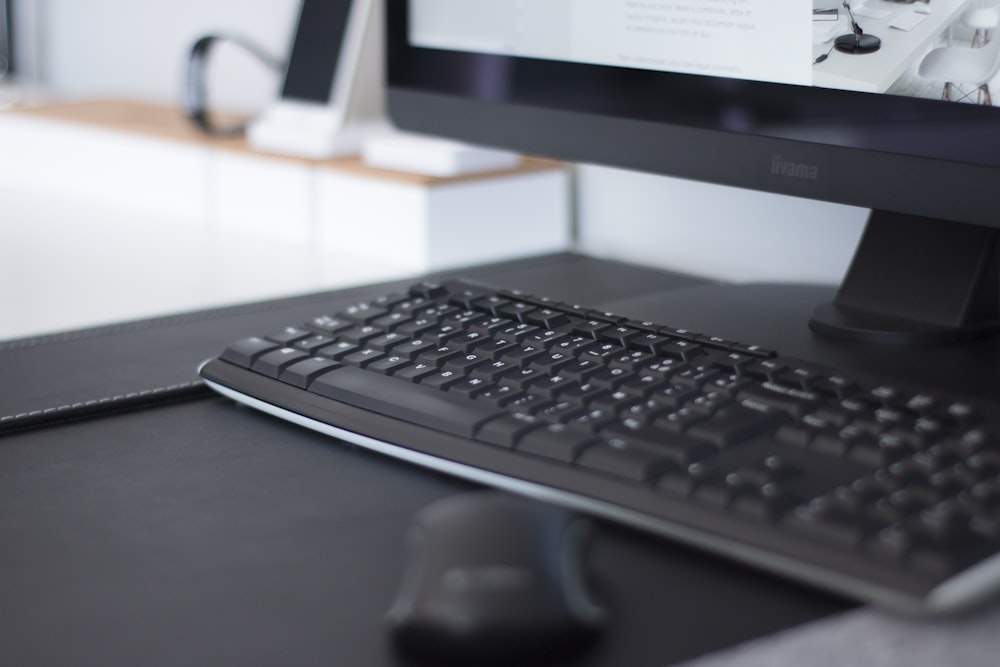 turned-on flat screen monitor and keyboard