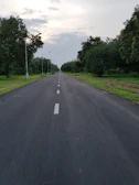 Wide concrete road lined with street lights inside Nagaraju Farm Land.